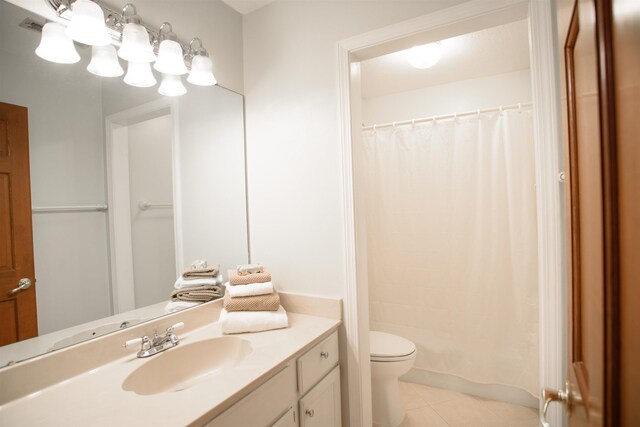 bathroom with tile patterned floors, vanity, toilet, and curtained shower