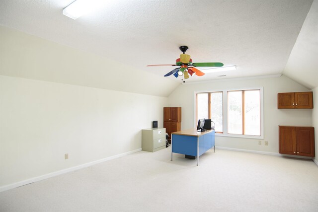 home office featuring a ceiling fan, light colored carpet, vaulted ceiling, and baseboards