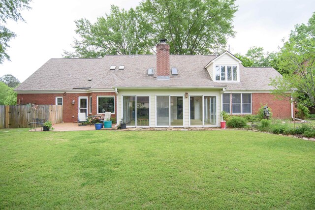 back of house with a patio, fence, a yard, and a chimney