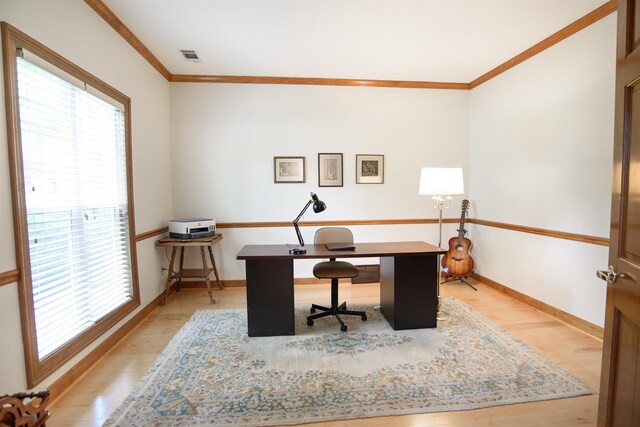 office space featuring visible vents, ornamental molding, and light wood-style floors