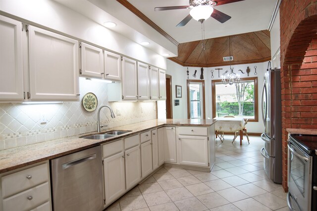 kitchen featuring visible vents, appliances with stainless steel finishes, a sink, ceiling fan with notable chandelier, and a peninsula