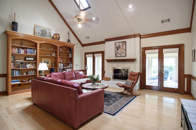 living area featuring high vaulted ceiling, ornamental molding, french doors, and a wealth of natural light