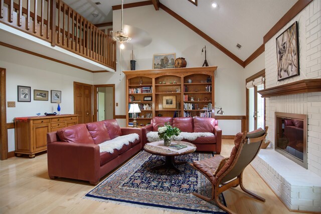 living area with crown molding, visible vents, a brick fireplace, high vaulted ceiling, and light wood-style flooring