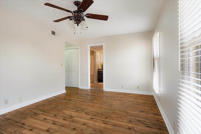 unfurnished room with a ceiling fan, baseboards, visible vents, and wood finished floors