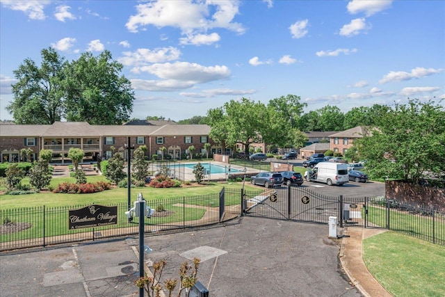 surrounding community with a lawn, fence, a residential view, and a gate