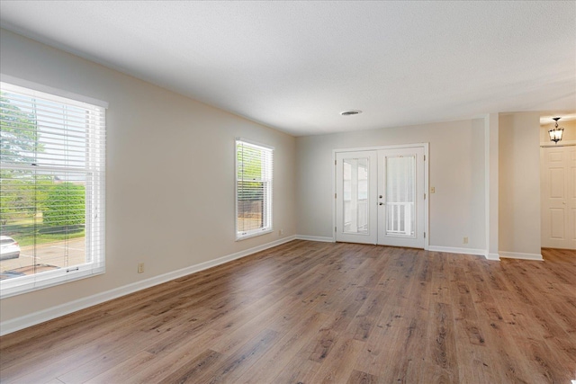 spare room featuring baseboards and wood finished floors