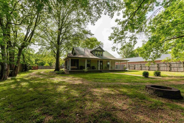 171 White St, Savannah, TN 38372 - back of house featuring a yard, covered porch, a fenced backyard, and an outdoor fire pit