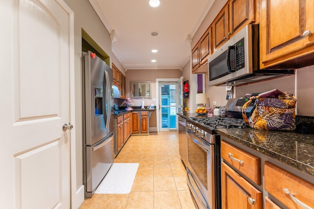 171 White St, Savannah, TN 38372 - kitchen with brown cabinets, light tile patterned flooring, crown molding, and appliances with stainless steel finishes