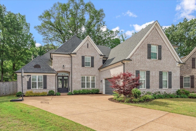 5082 Moudry Run Cv, Lakeland, TN 38002 - french country inspired facade with french doors, driveway, roof with shingles, and brick siding
