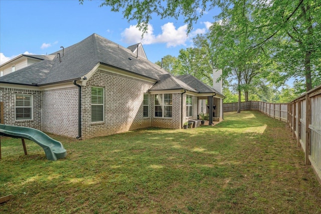 5082 Moudry Run Cv, Lakeland, TN 38002 - rear view of house with brick siding, a shingled roof, a lawn, and a fenced backyard