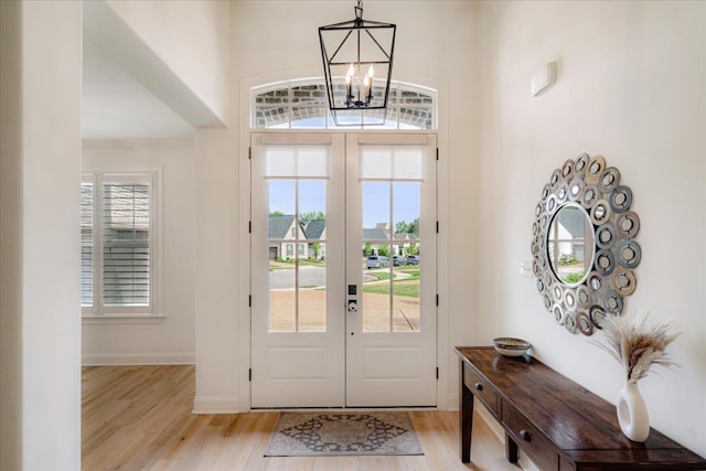 5082 Moudry Run Cv, Lakeland, TN 38002 - entryway featuring french doors, crown molding, baseboards, light wood finished floors, and an inviting chandelier