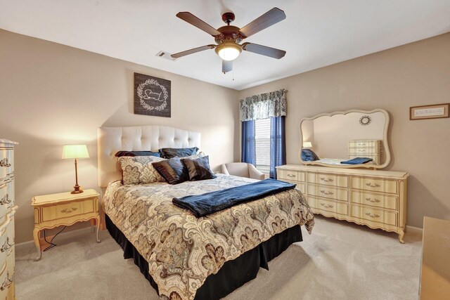 bedroom featuring baseboards, light carpet, a ceiling fan, and visible vents