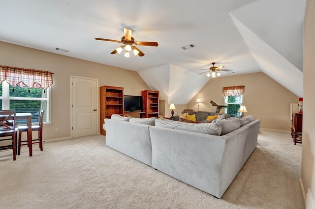 living room featuring visible vents, a ceiling fan, lofted ceiling, and light colored carpet