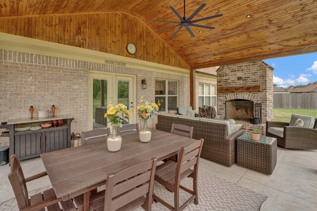 view of patio featuring french doors, a ceiling fan, an outdoor living space with a fireplace, and fence