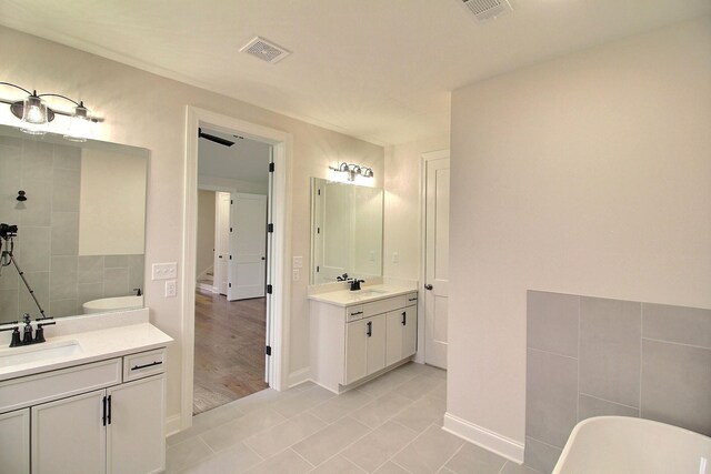 235 Freedom Ln, Rossville, TN 38066 - bathroom featuring visible vents, a freestanding bath, two vanities, a sink, and tile patterned floors