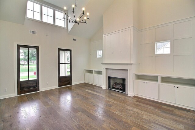 235 Freedom Ln, Rossville, TN 38066 - unfurnished living room with an inviting chandelier, a fireplace, high vaulted ceiling, wood finished floors, and visible vents