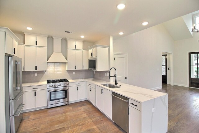 235 Freedom Ln, Rossville, TN 38066 - kitchen with a peninsula, high quality appliances, tasteful backsplash, custom range hood, and a sink