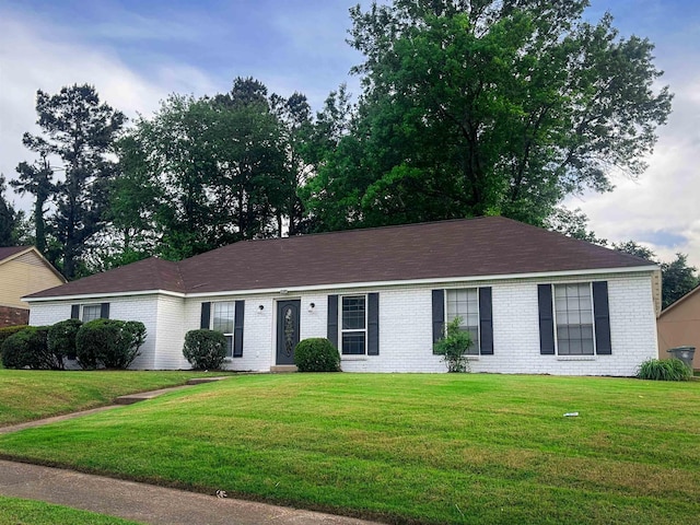 ranch-style home featuring brick siding and a front yard