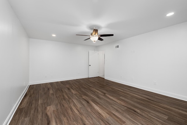 unfurnished room featuring baseboards, a ceiling fan, dark wood-type flooring, and visible vents