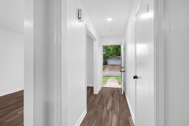 corridor featuring recessed lighting, baseboards, and dark wood-style flooring
