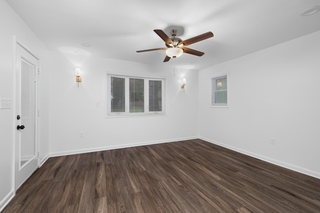 spare room featuring baseboards, a ceiling fan, and dark wood-style floors