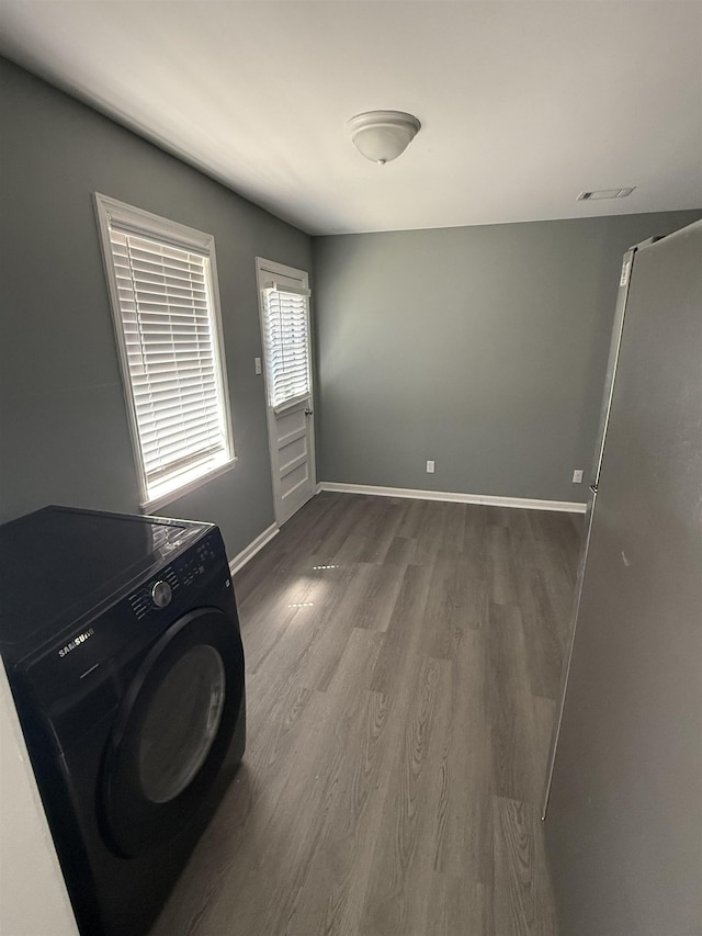 laundry area featuring baseboards, washer / clothes dryer, and wood finished floors