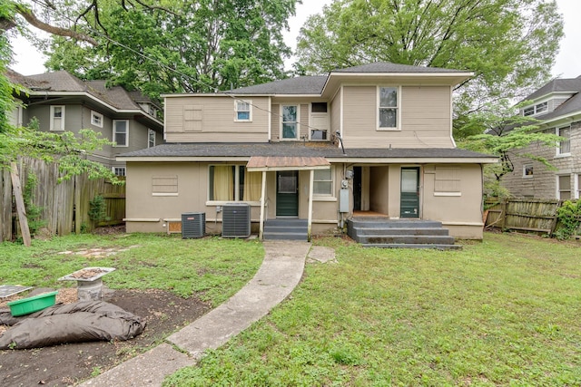 rear view of property featuring a lawn, a fenced backyard, roof with shingles, and cooling unit