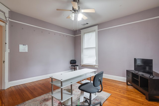office with baseboards, visible vents, ceiling fan, and light wood-style floors