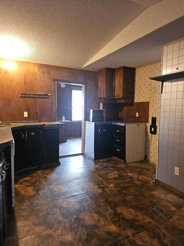 3845 Forked Deer Rd, Gates, TN 38037 - kitchen featuring light countertops, a textured ceiling, and wood walls