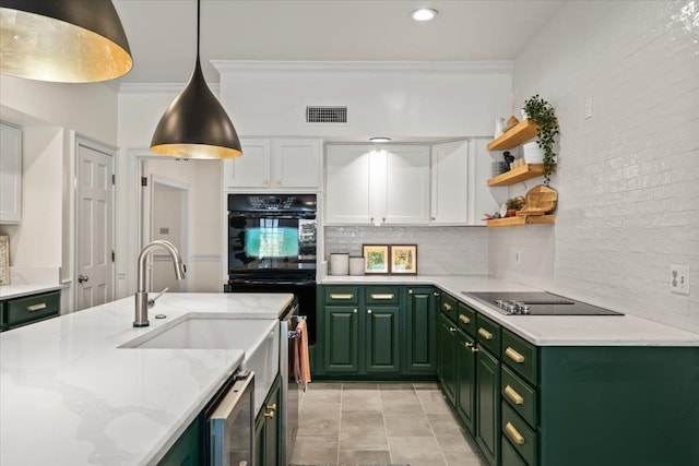 kitchen with backsplash, visible vents, black appliances, and green cabinets