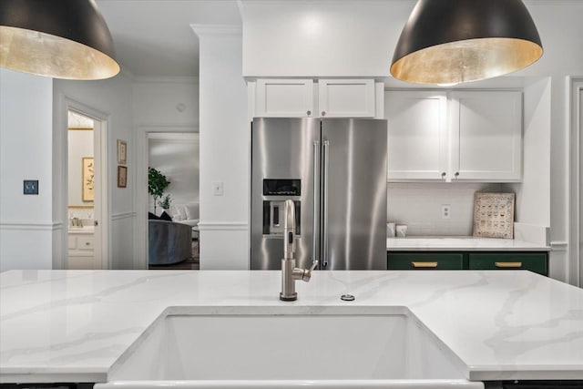 kitchen with light stone countertops, a sink, stainless steel fridge with ice dispenser, and tasteful backsplash
