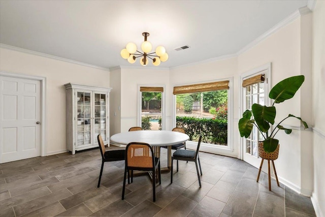 dining space featuring crown molding, a chandelier, baseboards, and visible vents