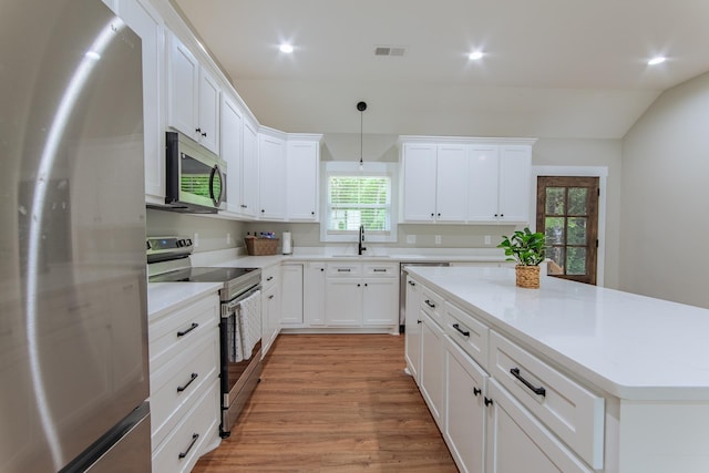 50 Melrose Cv, Savannah, TN 38372 - kitchen with a sink, appliances with stainless steel finishes, vaulted ceiling, white cabinetry, and light wood-style floors