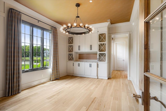 294 Dubray Manor Dr, Collierville, TN 38017 - unfurnished dining area featuring an inviting chandelier, baseboards, and light wood-style floors