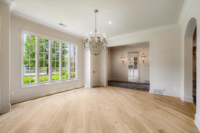 294 Dubray Manor Dr, Collierville, TN 38017 - unfurnished dining area with crown molding, a notable chandelier, arched walkways, light wood-type flooring, and visible vents