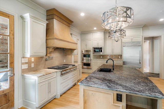 294 Dubray Manor Dr, Collierville, TN 38017 - kitchen featuring a sink, custom exhaust hood, a notable chandelier, stainless steel appliances, and light wood-style flooring