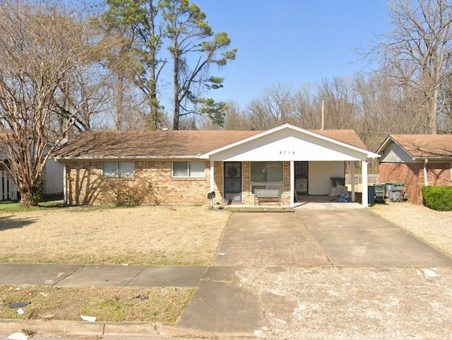 4714 Hillmont Ave, Memphis, TN 38122 - view of front facade with a front yard, concrete driveway, a porch, and brick siding