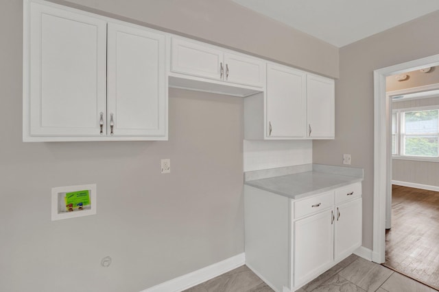 kitchen featuring light countertops, baseboards, and white cabinets