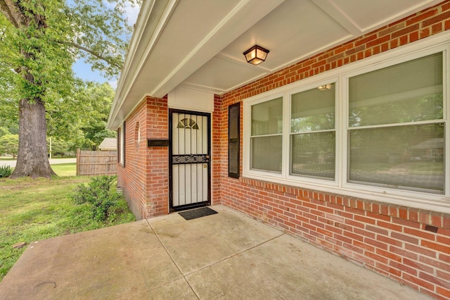 view of exterior entry featuring brick siding