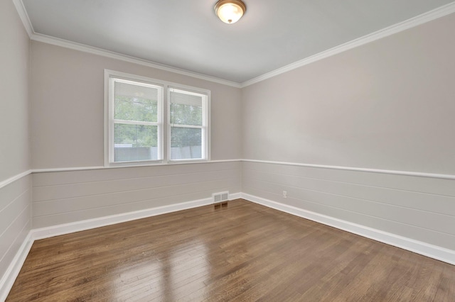 unfurnished room featuring baseboards, visible vents, dark wood-style floors, and ornamental molding
