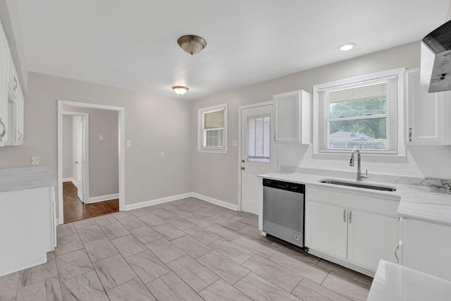 kitchen featuring light countertops, white cabinetry, a sink, dishwasher, and exhaust hood