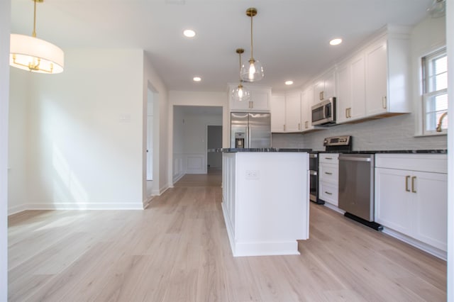 5483 Brantford Rd, Memphis, TN 38120 - kitchen with dark countertops, light wood-style floors, a center island, white cabinets, and appliances with stainless steel finishes