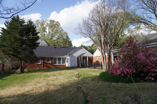 5483 Brantford Rd, Memphis, TN 38120 - back of property featuring a yard, brick siding, and fence