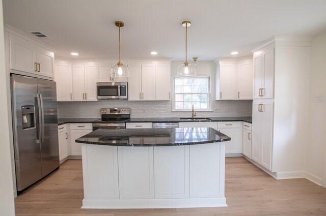 5483 Brantford Rd, Memphis, TN 38120 - kitchen featuring light wood-style floors, a sink, appliances with stainless steel finishes, and white cabinets