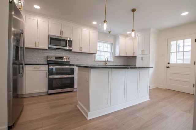 5483 Brantford Rd, Memphis, TN 38120 - kitchen featuring backsplash, dark countertops, appliances with stainless steel finishes, white cabinets, and light wood-style floors
