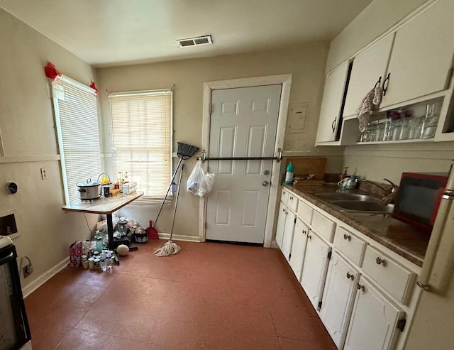 interior space with a sink, baseboards, and visible vents