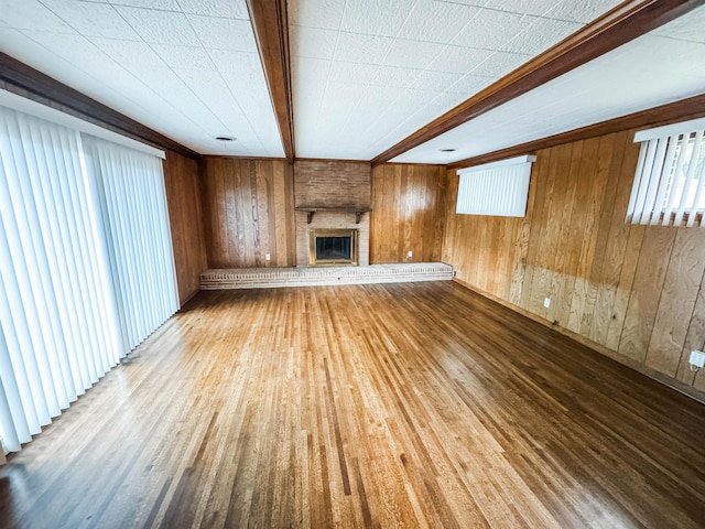 1439 Woodston Rd, Memphis, TN 38117 - unfurnished living room with wooden walls, a brick fireplace, and wood finished floors