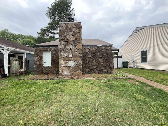 4805 Northfield Cir, Memphis, TN 38128 - exterior space featuring a chimney, roof with shingles, a yard, and stone siding