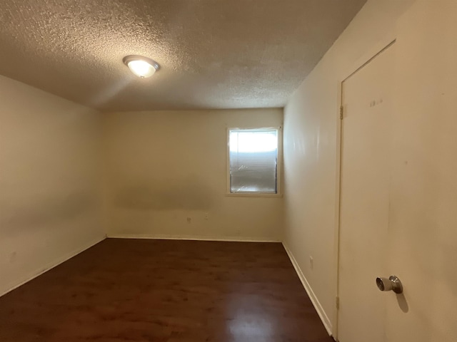 4805 Northfield Cir, Memphis, TN 38128 - empty room featuring a textured ceiling, dark wood-style floors, and baseboards