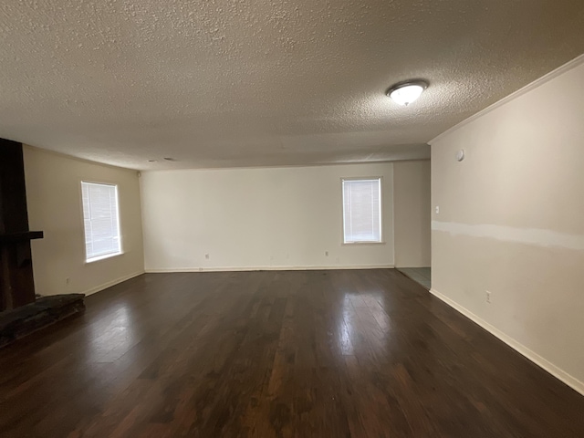 4805 Northfield Cir, Memphis, TN 38128 - spare room featuring baseboards, a textured ceiling, dark wood-style flooring, and a wealth of natural light